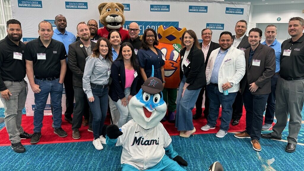Comcast team poses with South Florida Sports Mascots